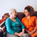 Image of two women smiling on a couch